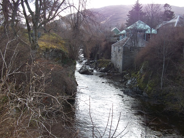 The River Dee surrounded by trees with a mountain above