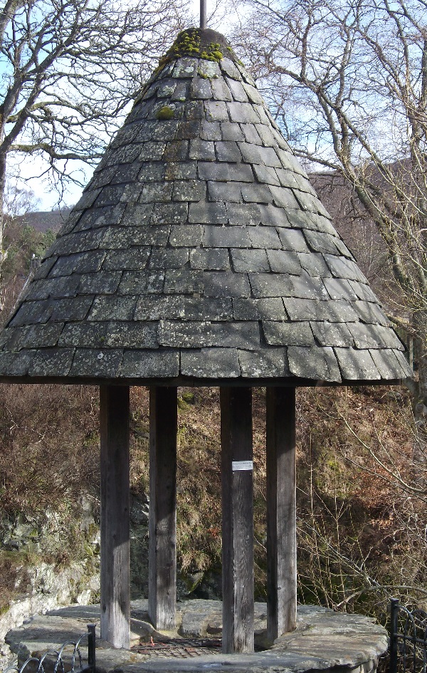 A wishing well with a slate roof