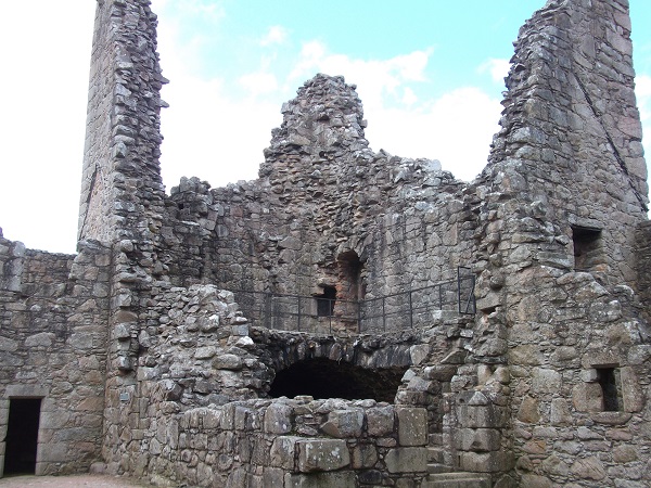 the ruined walls of a castle, with lower floor intact and only the high walls of upper floors remaining