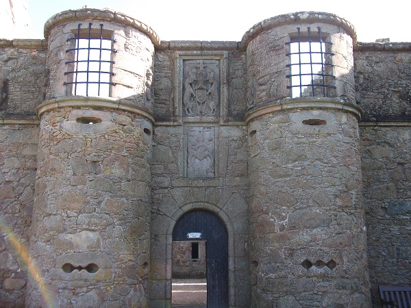 A stone gatehouse with windows and gunholes