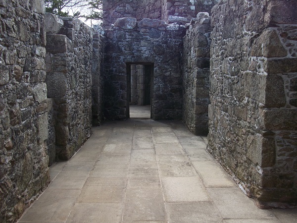 A paved room with ruined walls around
